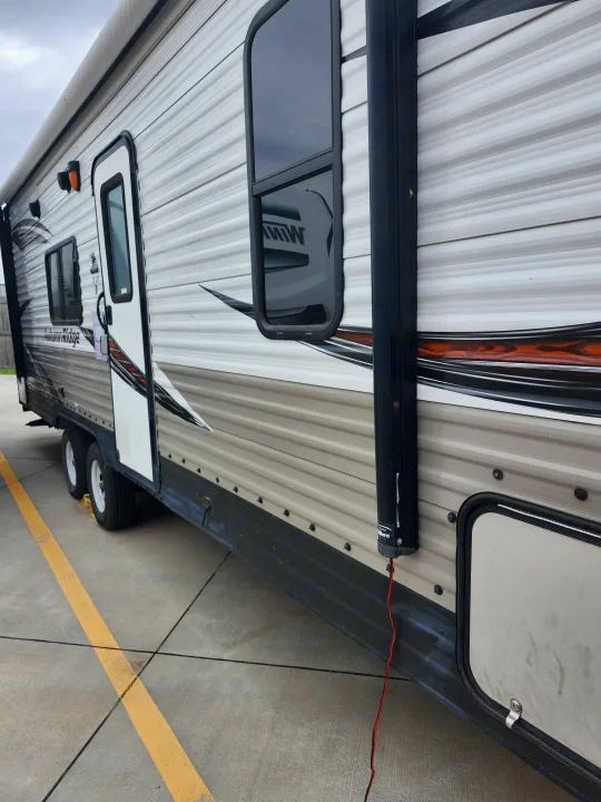 RV rental: Side view of a gray and white travel trailer, showing its awning, windows, door, and graphic details.. Starcraft Autumn Ridge 2018