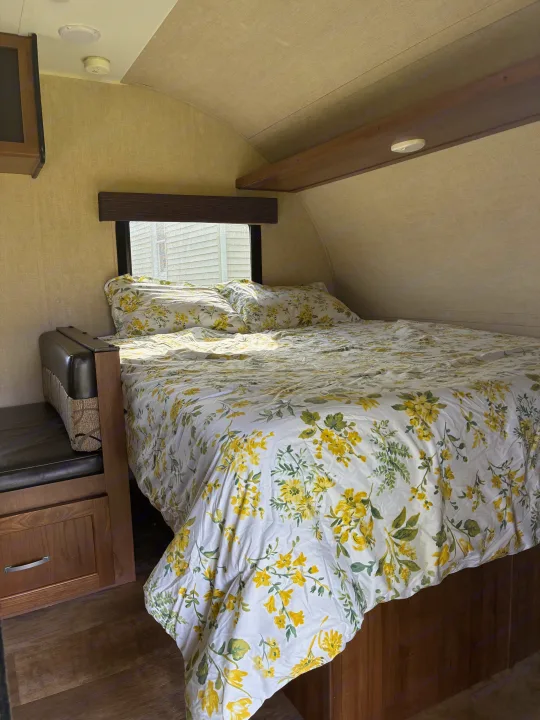 RV rental bedroom: cozy bed with cheerful yellow floral bedding & window.. Gulf Stream Ameri-Lite 2019