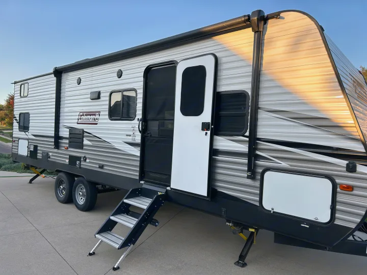 Bright, modern Coleman travel trailer with open door and steps. Perfect for your next RV rental adventure.. Dutchmen Coleman Lantern 2020