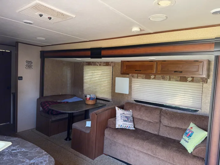 Cozy RV rental interior showcasing a dinette, sofa, and overhead storage, perfect for your next road trip adventure.. Jayco Jay Flight SLX 2016