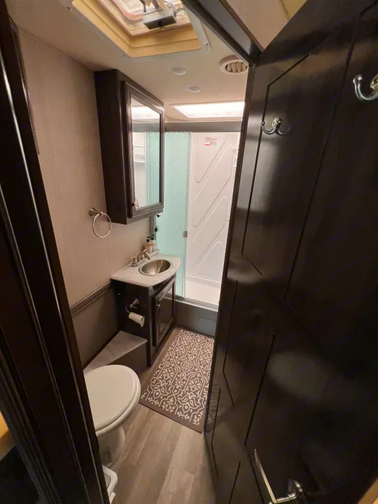 RV rental: Bright, compact bathroom showcasing a toilet, sink, and shower stall for convenient travel.. Flair-Fleetwood Flair-Fleetwood Motorhome 2020