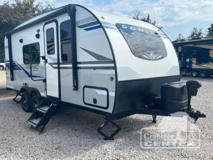 This white and gray Sonic travel trailer, ideal for an rv rental, features an awning, steps, and front propane tanks.. Venture Sonic 190VRB 2022