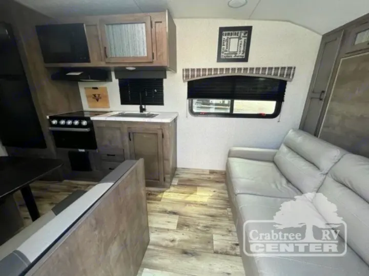 RV rental interior: kitchen with stove, sink, microwave, cabinets; plus a comfy sofa and dining area.. Venture Sonic 190VRB 2022