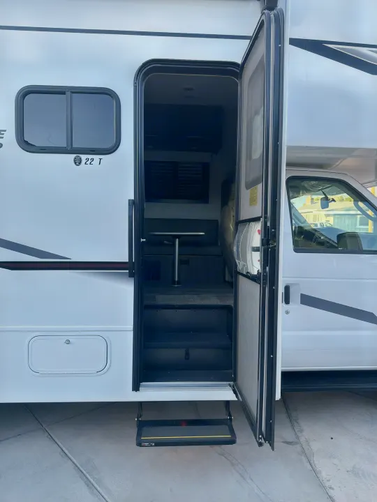 Open door of a white RV rental, showing interior steps and dining area. Perfect for adventures.. JAYCO REDHAWK SE 22TF 2025