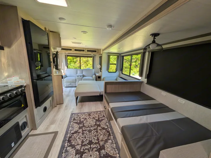 Spacious RV rental interior featuring a modern kitchen, comfortable living area with recliner sofa, and a convertible dinette.. Forest River Alta 2850KRL 2025