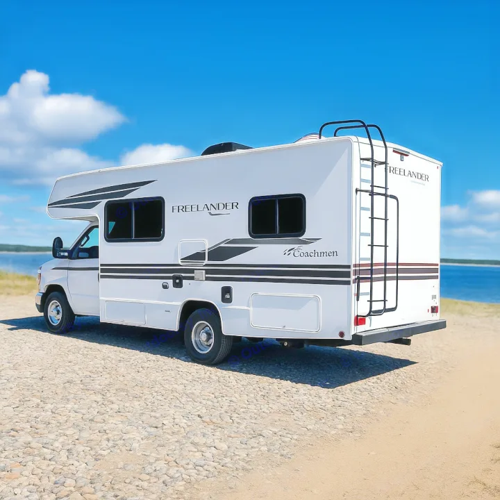 This white Class C rv rental, a Coachmen Freelander, is parked on a beach-like shore under a bright blue sky, ready for adventure.. Coachman Freelander 22 XG 2023