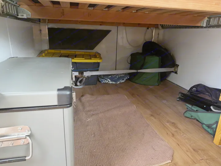 RV rental under-bed storage features a secured portable fridge, bins, and camping gear with a tie-down strap.. Weeroll Silver cloud 2020