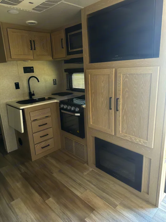 RV rental: Modern interior featuring a light wood kitchen, built-in TV, and electric fireplace.. Forest River Flagstaff Micro Lite 2023
