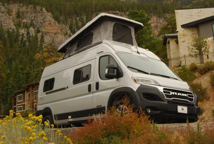 Silver Solis pop-top RV rental parked in a stunning mountain setting with pine trees, perfect for your next adventure.. Winnebago Soilis 2025