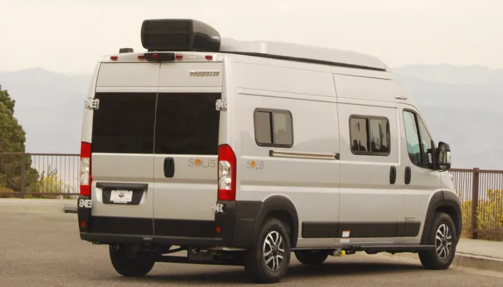 This RV rental, a Winnebago Solis camper van, is parked with a scenic mountain view under a cloudy sky.. Winnebago Soilis 2025