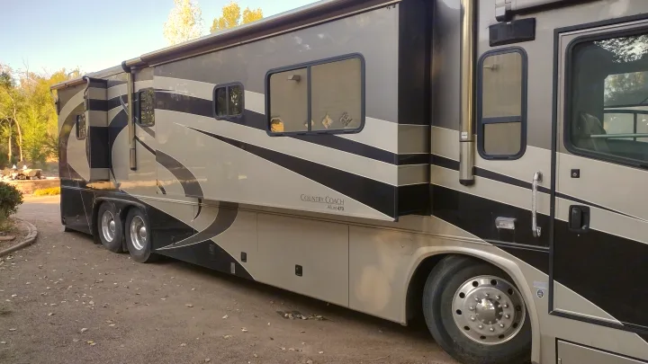 This spacious Country Coach Allure 470 luxury motorhome is perfect for your next RV rental. Features a tan & black design with multiple windows.. Country Coach Allure 470 2005