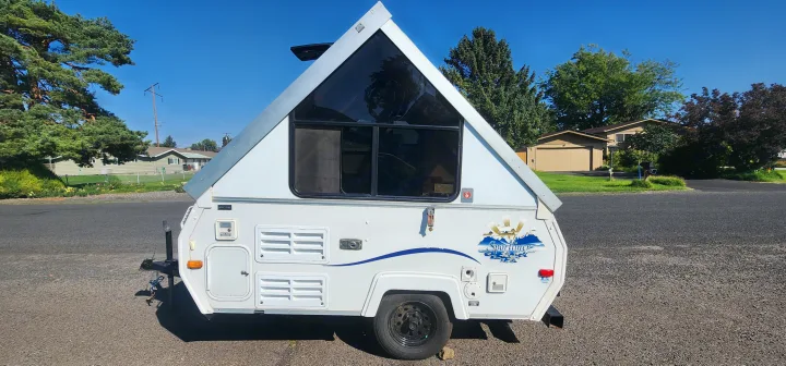 Compact A-frame rv rental, a white pop-up camper, ready for your next travel adventure and camping trip.. A Liner A Liner Popup Trailer 2006