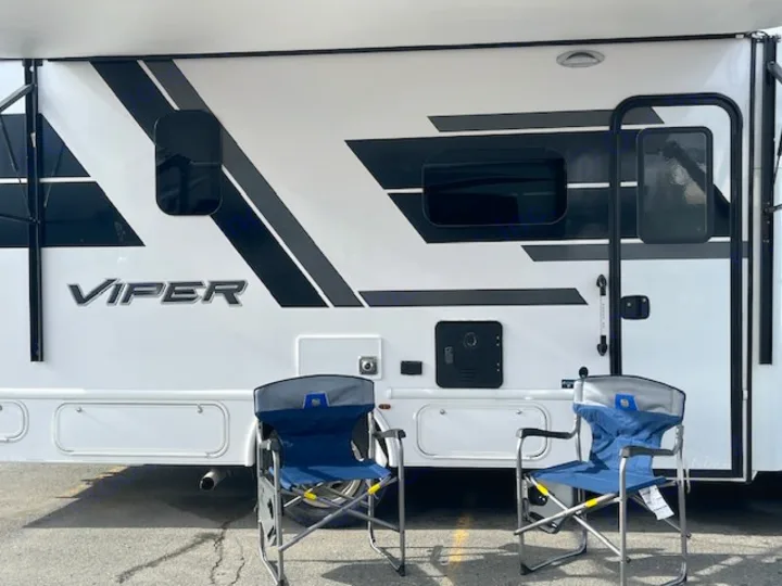 RV rental exterior with Viper branding, two blue camping chairs set up for a relaxing outdoor experience.. Nexus Viper 2026