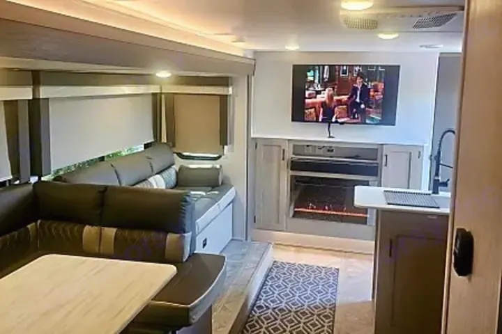 Inside a spacious **RV rental**: living area with U-shaped sofa, TV, electric fireplace, and a compact kitchen counter.. Salem Cruise LIte Platinum 28VBLX 2024