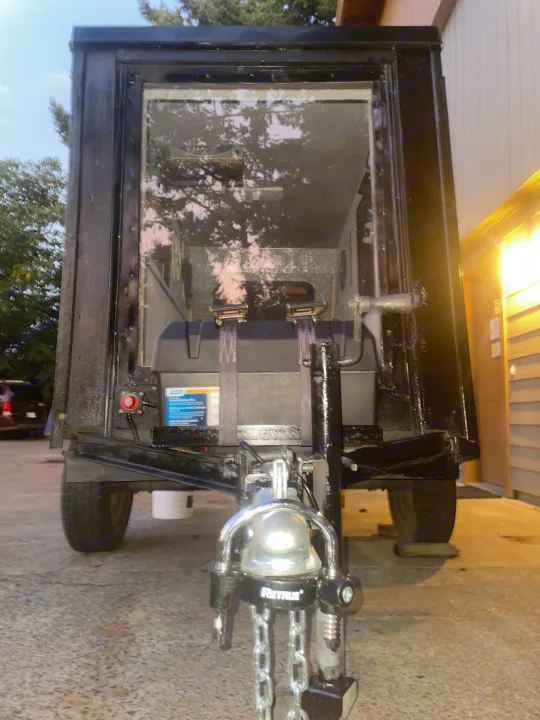 Rear view of a unique RV rental trailer, revealing interior straps, a battery box, and hitch details, ready for its next adventure.. Custom Squaredrop Trailer 2020