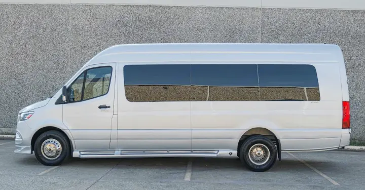 This silver luxury conversion van, ideal for rv rental, features tinted windows, running boards, and chrome wheel covers.. Mercedes Benz Sprinter By Legends Executive 2022