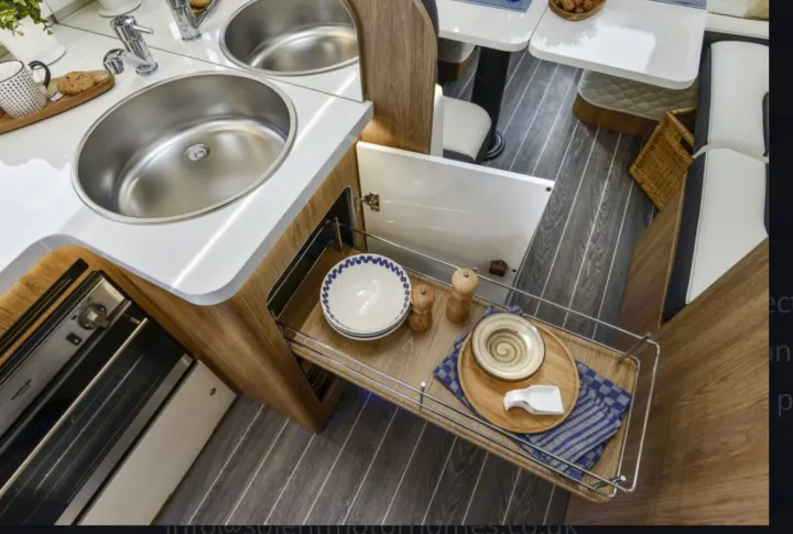 Discover this RV rental's compact kitchen, featuring dual sinks, oven, and smart pull-out storage for dining essentials.. Roller Team 707 Auto Roller 2025