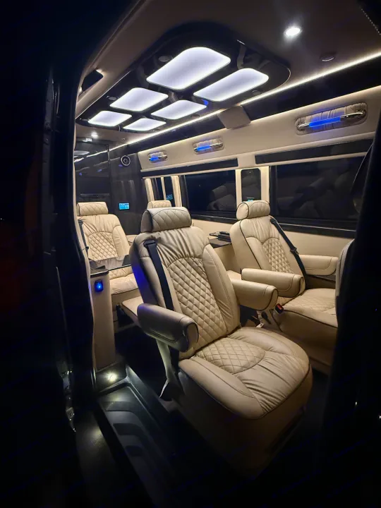 Luxurious RV rental interior with plush cream leather seats and ambient lighting, perfect for comfortable travel.. Ultimate Toys Ultimate Coach 2023