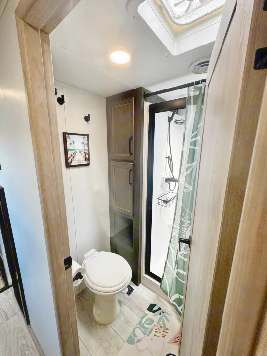 Modern RV rental bathroom: features a sleek shower, toilet, and storage, perfect for your next travel adventure.. Keystone RV Montana High Country 2024