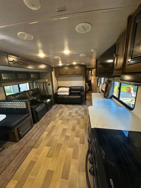RV rental interior featuring a modern kitchen, comfortable sofa, and dinette. Bright, spacious living area for travel.. Heartland RVs Mallard 2020