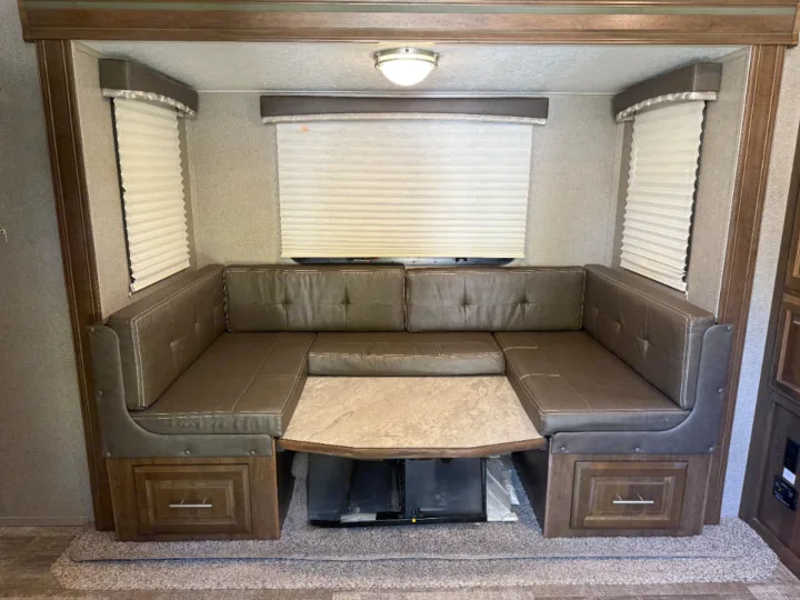 U-shaped dinette in an rv rental, featuring padded brown seating, a tabletop, and convenient under-seat storage drawers.. Forest River Rockwood Mini Lite 2020