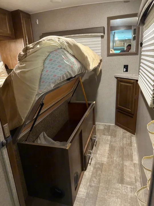 Smart RV rental bed with lift-up storage and built-in cabinets, maximizing space in this compact interior.. Forest River Rockwood Mini Lite 2020