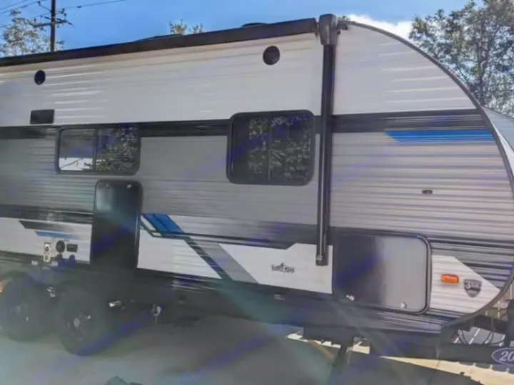 Side view of a modern grey and black travel trailer rv rental with an awning and windows, ready for adventure.. Heartland RVs Pioneer 2023