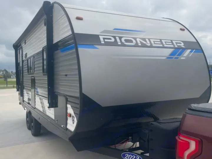 This new 2023 Pioneer travel trailer in grey and black is hitched, ready for your next RV rental adventure.. Heartland RVs Pioneer 2023