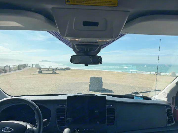 Enjoying a stunning coastal view from an RV rental, capturing ocean waves and a picnic area from inside the van.. ModVans ModVans Class B 2022