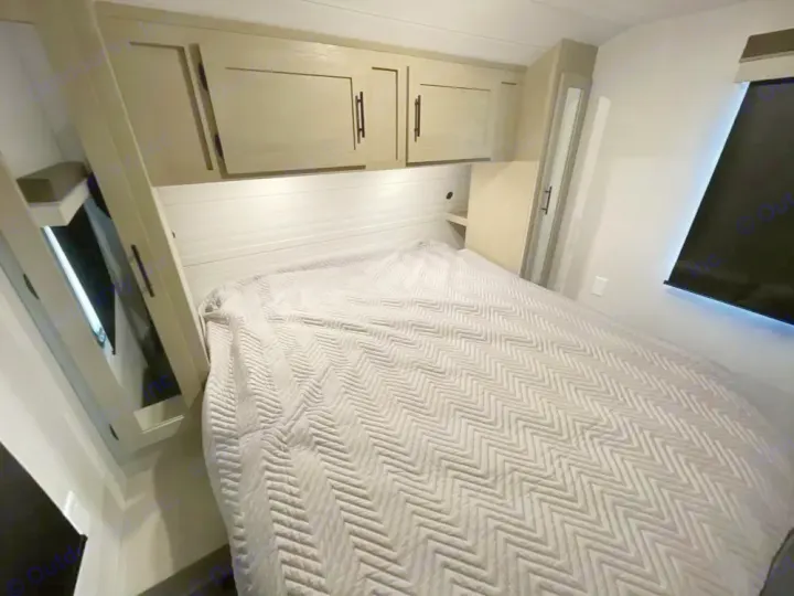 RV rental bedroom: grey chevron bed, overhead cabinets for storage, and integrated lighting for a compact space.. Forest River Salem Platinum 2024