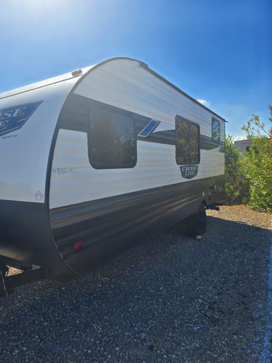 Cruise Lite travel trailer RV rental parked on gravel under a sunny blue sky.. Forest River Salem Cruise Lite 2024