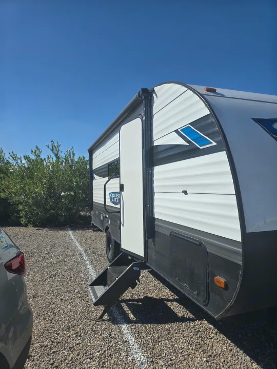 RV rental: A two-tone white and black travel trailer with steps extended, parked on gravel under a clear blue sky.. Forest River Salem Cruise Lite 2024