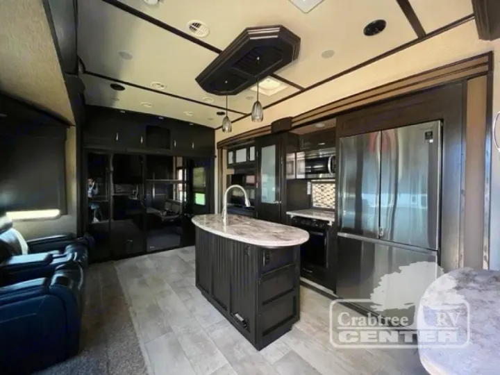 Spacious, modern RV rental interior featuring a full kitchen with island, stainless steel appliances, and cozy living area.. Grand Design Momentum 2015