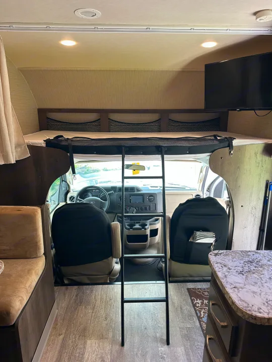 Experience comfort in this RV rental! Features an overhead bunk bed with ladder, spacious driver's cab, and cozy living area.. Jayco Redhawk 2018