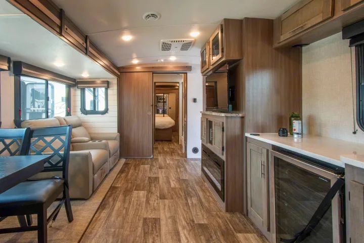 RV rental: comfortable interior with dining, recliners, kitchen counter, entertainment, and bedroom access.. Crossroads RV Sunset Trail 2022