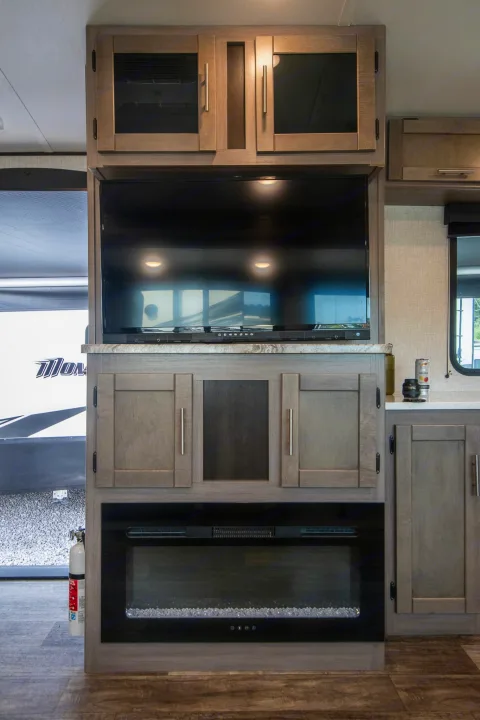 RV rental interior features a modern entertainment center with a flat-screen TV, sleek cabinets, and an electric fireplace.. Crossroads RV Sunset Trail 2022