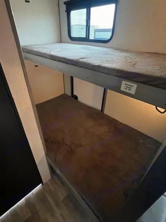 RV rental bunk beds, perfect for family camping trips. A window offers views from the top bunk for comfortable stays.. Dutchmen Kodiak Cub 2022