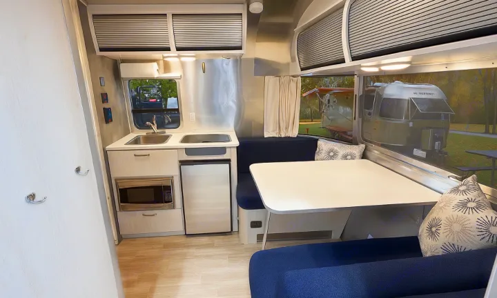 Modern rv rental interior with compact kitchen, cozy dinette, and sleek design, perfect for travel trailer adventures.. Airstream Bambi 2024