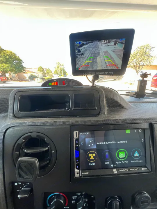 Dashboard of an RV rental, showing a rearview camera feed, parking sensors, and a modern infotainment system.. Thor Majestic 2019