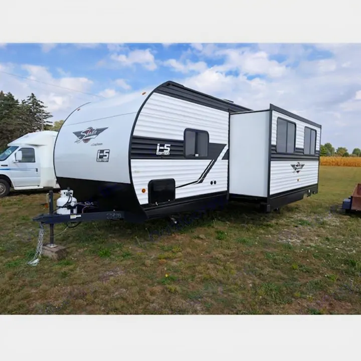 Spacious white & black travel trailer with slide-out, ideal for RV rental. Parked on grass outdoors.. Coachmen I-5 Edition 530QB 2024