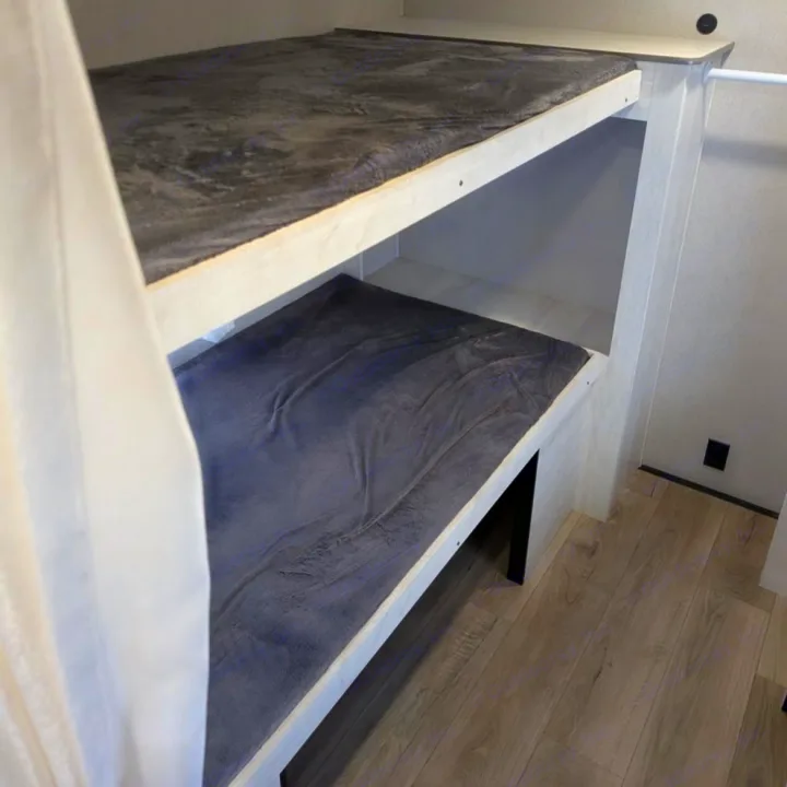 Cozy gray bunk beds in this RV rental offer a comfortable, compact sleeping area with light-colored frames.. Coachmen I-5 Edition 530QB 2024