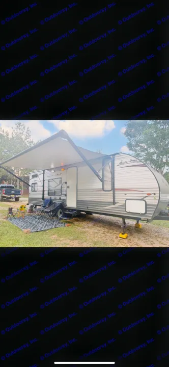 Relaxing rv rental setup with an awning & chairs at a peaceful campsite, perfect for outdoor adventures.. Forest River Cherokee Grey Wolf 2014
