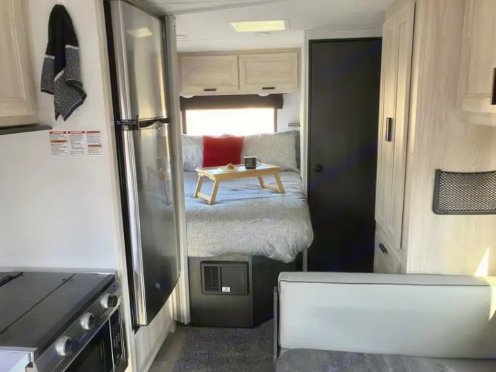 Modern rv rental interior with compact kitchen, cozy bed, and seating area. Perfect for comfortable travel adventures.. Forest River Forester 2026