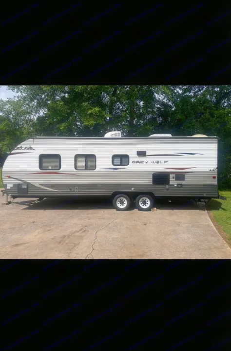Full side view of a Grey Wolf travel trailer, an excellent RV rental option parked outdoors.. Forest River Cherokee Grey Wolf 2014