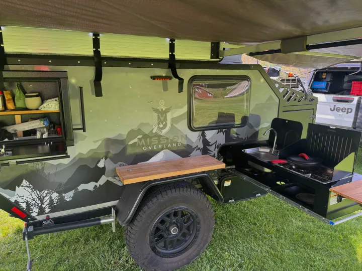 Mission Overland trailer's outdoor kitchen. Sink, stove, and counter space for camping or an RV rental. Ready for adventure!. Mission Overland Summit 2024