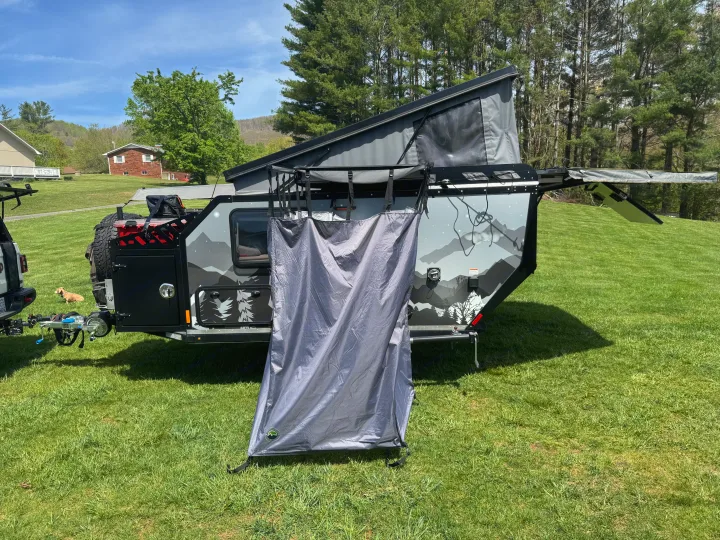 RV rental: Off-road pop-up camper trailer with privacy tent ready for adventure. Sunny day, grassy field, mountain views.. Mission Overland Summit 2024
