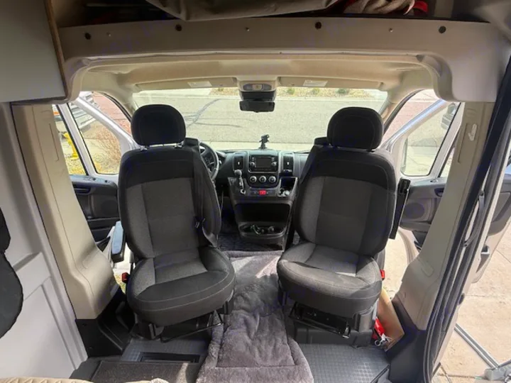RV rental: Interior view of a camper van's front cabin with swivel seats & dashboard, ready for journeys.. Winnebago Solis 2022