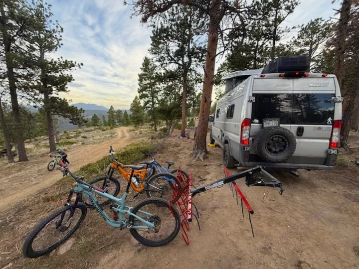 RV rental: Camper van & mountain bikes on a scenic dirt trail, ready for outdoor adventure in the mountains.. Winnebago Solis 2022