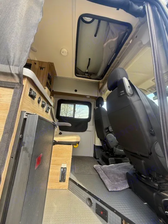 This RV rental offers a cozy interior: swiveling front seats, compact storage, a control panel, and a ceiling vent.. Winnebago Solis 2022