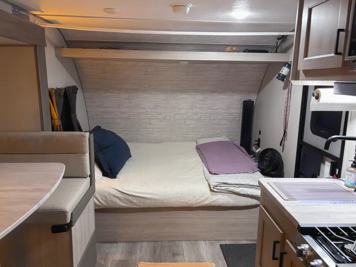 This RV rental's cozy interior features a bed, dinette, and kitchen, designed for compact comfort on your travels.. Coachmen 184BH 2025